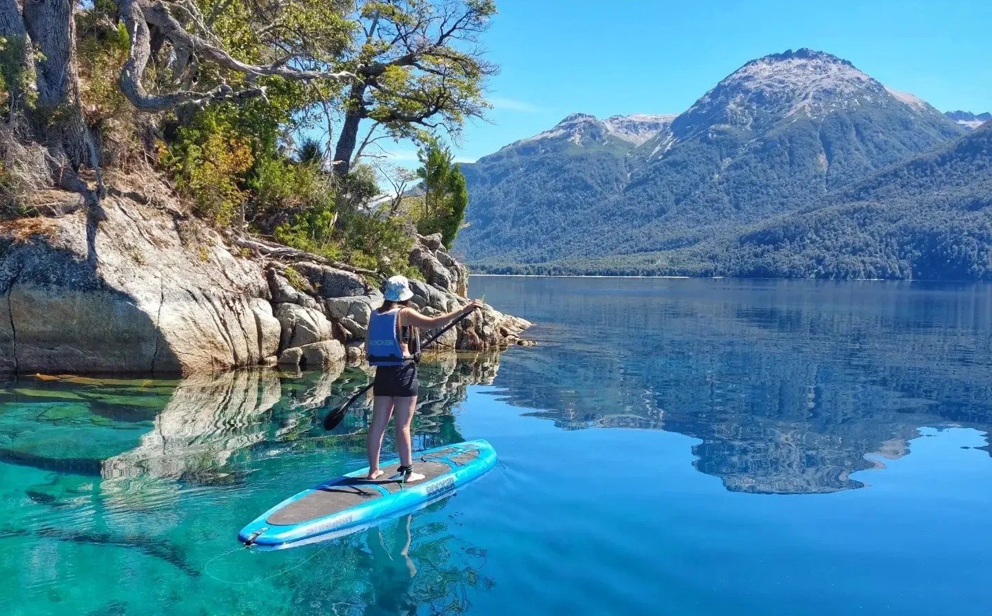 Vista del lago Traful y el bosque sumergido, con la cordillera de fondo. La imagen transmite la calma y el aislamiento de este rincón de la Patagonia, antes de que la pavimentación de la Ruta 65 transforme el destino.